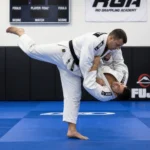 Jiu-jitsu sırasında rakibinin formasını tutarken parmak fleksör tendonunda ani çekilme yaralanmasını temsil eden sporcu görseli.